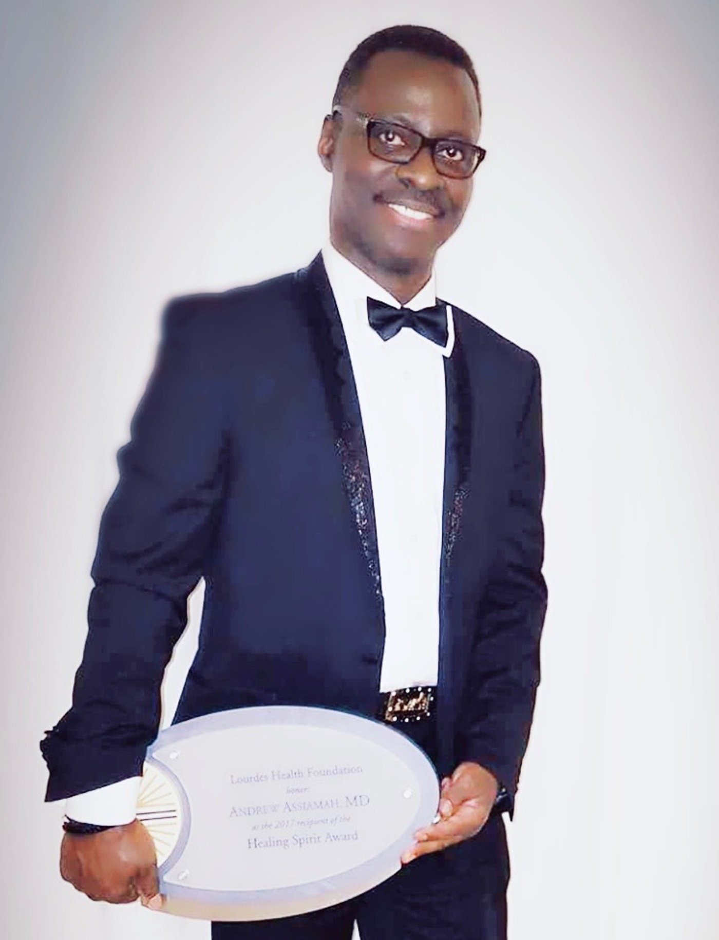 Dr. Andrew Assiamah holding the 2017 Healing Spirit Award